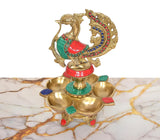 Close view of brass oil lamp base with peacock figure and five small diya bowls