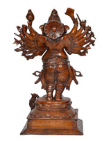Close view of brass Ganesha statue face and 16 hands, seated on ornate pedestal