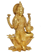 Brass Lakshmi statue holding a pot, seated on lotus petals with ornate patterns