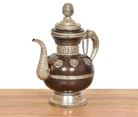 Traditional brass teapot with filigree front medallions, dark brown round base