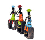 Three iron musician figurines in colourful dresses, standing on dark wooden block bases