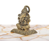 Side view of Lord Ganesha idol with raised hands, beaded body texture, and ornate base.