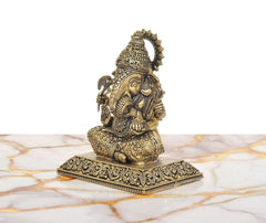 Side view of Lord Ganesha idol with raised hands, beaded body texture, and ornate base.