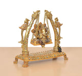 Angled view brass Ganesha swing idol with multicolor meenakari on the jhula base