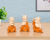 Small seated monk Buddha sculpture set in orange robes, resin figurines