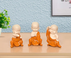 Small seated monk Buddha sculpture set in orange robes, resin figurines