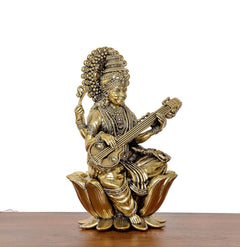 Brass Maa Saraswati statue holding veena, seated on lotus, profile view