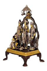 Brass Ram Darbar statue from side angle showing canopy, four figures, and gold-trimmed base