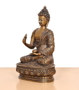 Brass Buddha statue in Abhaya mudra, side view with patterned robe and seated base