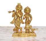 Gold-tone brass Radha Krishna idol standing on ornate base with peacock.