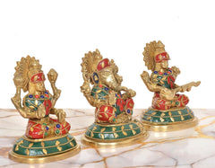 Side view of brass Lakshmi, Ganesh & Saraswati idols, multicolor paint and gold accents.
