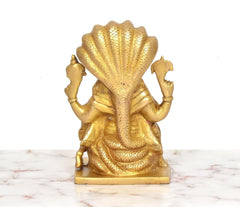 Brass Narasimha statue back view, textured shoulder scales and gold finish