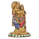 Brass Radha-Krishna statue with jeweled necklaces and striped base; close angle