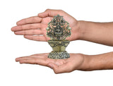 Brass Laxmi diya oil lamp held in hands, ornate base, 4-inch height