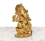 Golden brass Ganesha statue, three-quarter angle sitting on lotus base