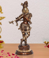 Brass Krishna flute idol statue with ornate crown, standing on round base