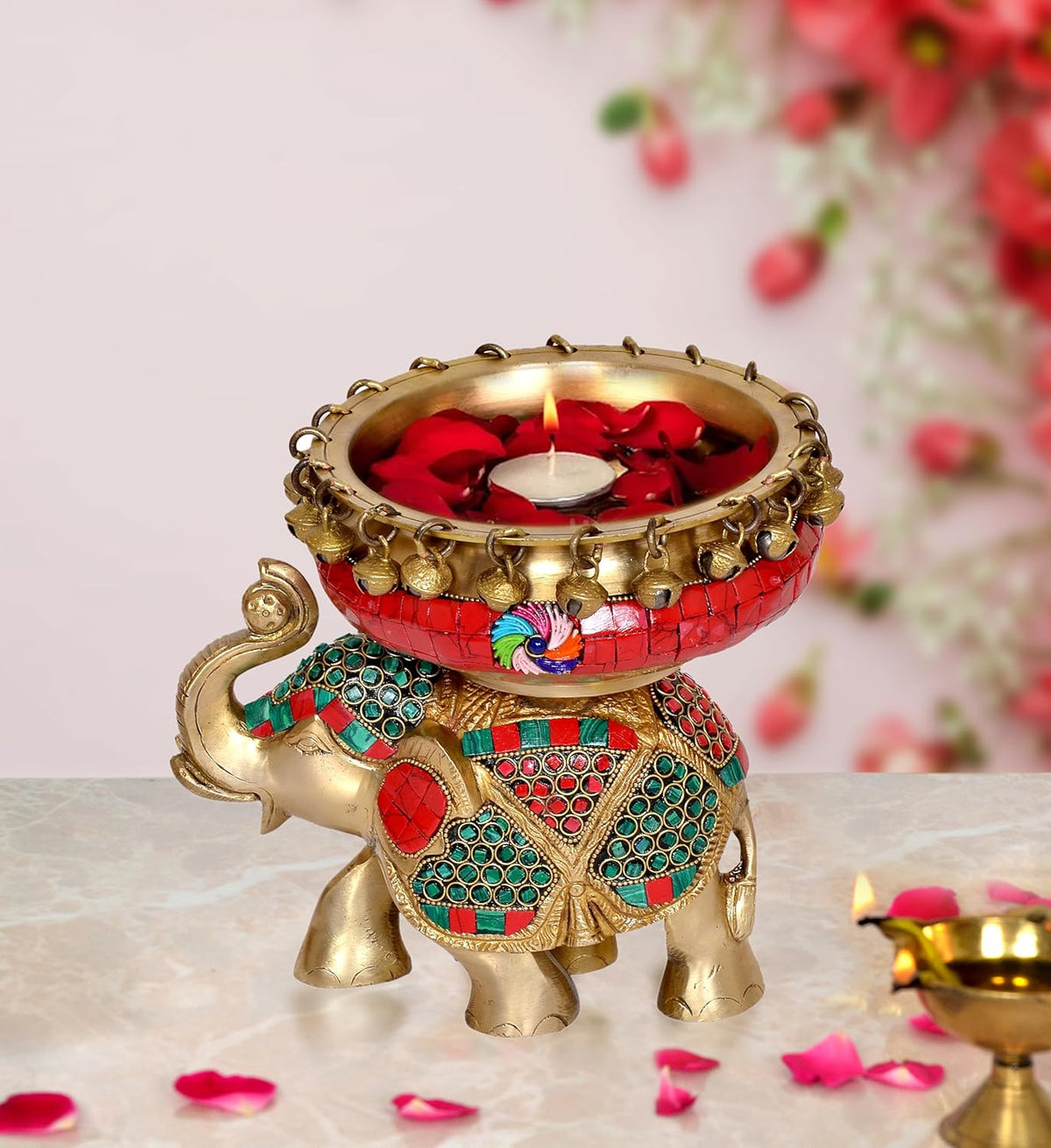 Brass elephant idol with red jeweled urli diya bowl and colorful ghungroo trim