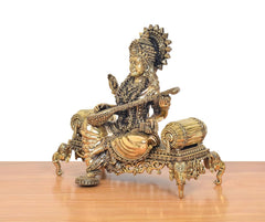 Saraswati brass idol on throne, side view with detailed ornaments and veena
