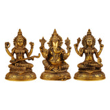 Brass idol set with three seated deities—Lakshmi, Ganesha, Saraswati—front view