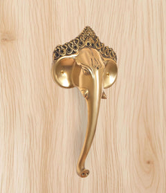 Golden brass Ganesha face door handle with detailed trunk and rounded side plates