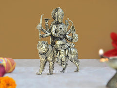 Brass Durga Maa statue on lion, angled view with ornate belt and holding implements