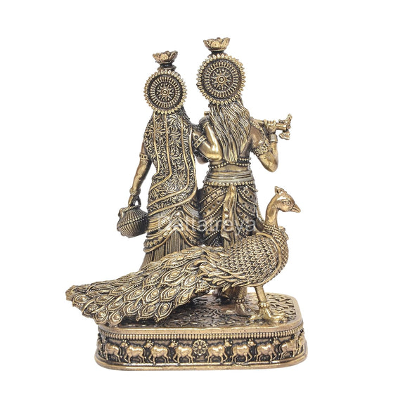 Brass Radha Krishna idol statue viewed from back, ornate disc headpieces and flute