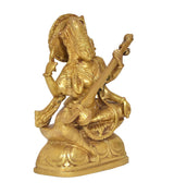 Golden brass Saraswati idol in profile, holding veena and seated on lotus base