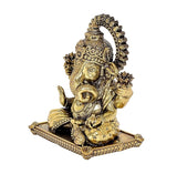 Brass Ganesha statue idol side view, decorative ornaments and seated base