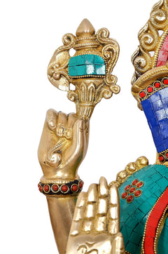 Close-up of raised blessing hand and teal jewel panel on a gold brass arm