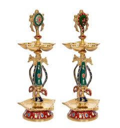 Two brass shankh chakra diya idols, green and red enamel with five-tier lamp bowls