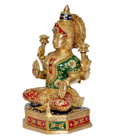 Brass Lakshmi idol side view, four arms holding diyas, ornate green and red dress