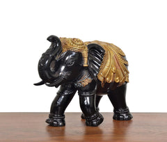 Black and gold elephant figurine, angled side view, decorated golden saddle and trunk