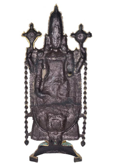 Dark back view of ornate brass Tirupati Bala Ji showpiece, raised detailing, stand base
