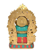 Brass Ganesha idol back view, textured golden halo and colorful red-teal lower body