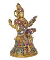 Brass Saraswati idol three-quarter view seated on lotus, veena and multicolor jeweled outfit