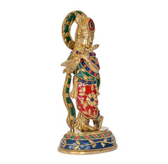 Brass Krishna idol statue, profile view with green halo and red robe, on round base