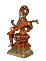 Side view brass Saraswati statue seated with veena across lap, raised hands