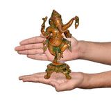 Brass dancing Ganesha statue held in hands for size; green-gold accents on base
