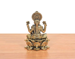 Seated Lakshmi goddess idol with ornate halo crown and lotus base, bronze finish