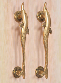 Golden brass dolphin fish door handle pair, angled view showing lever detail