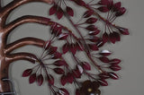 Iron tree wall art close-up with burgundy leaf accents on curved metal branches