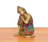 Side view of brass seated Buddha idol with jeweled-style multicolor robe accents