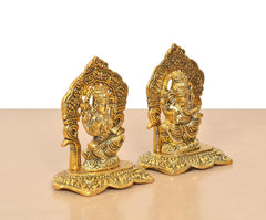 Golden metal Lakshmi and Ganesh statues angled view, intricate engravings on bases