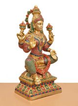 Lakshmi brass idol three-quarter view, ornate crown and multicolor patterned torso