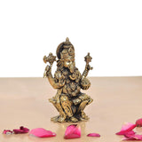 Brass Lord Ganesha idol, side view, seated on ornate base with engraved details.