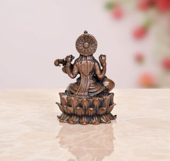 Rear view Saraswati Maa statue, copper-toned bronze, seated on lotus base