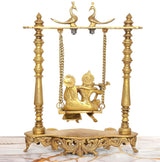 Brass Radha-Krishna swing idol, front view of golden seat with hanging chains