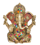 Front view of brass Ganesha idol with painted face, jeweled headpiece and four hands