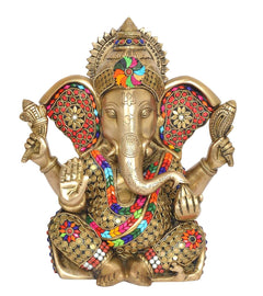 Front view of brass Ganesha idol with painted face, jeweled headpiece and four hands