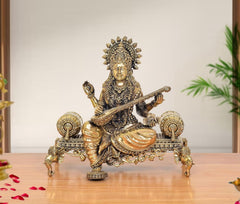Superfine Brass Saraswati idol on throne, holding veena, ornate crown and jewelry